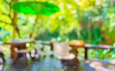 Arka plan kullanımı için yeşil ağaç bokeh ile gündüz vakti bulanık bir restoran görüntüsü .