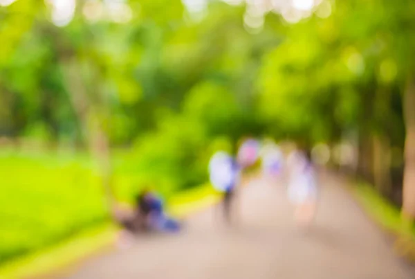 Stock image blur image of people walking in the park with bokeh for background usage .