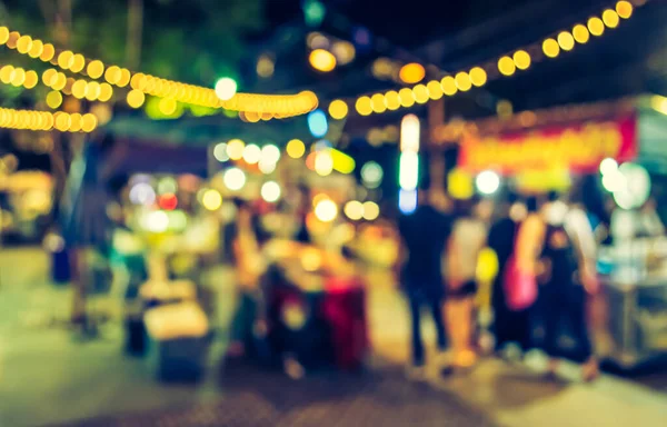blur image of night festival on street blurred background with bokeh . (vintage tone)