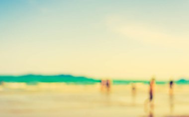 Arka plan kullanımı için sahilde yürüyen bulanık insanların soyut görüntüsü. (Klasik ton))