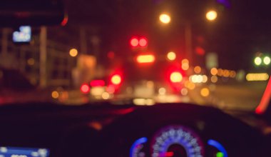 Arka plan kullanımı için gece vakti araba kullanan insanların klasik ton bulanık görüntüsü. (içeriden fotoğraf çek)