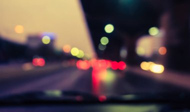 Arka plan için gece vakti trafik sıkışıklığından gelen bokeh ışıkları olan içerideki arabaların klasik ton bulanık görüntüsü.
