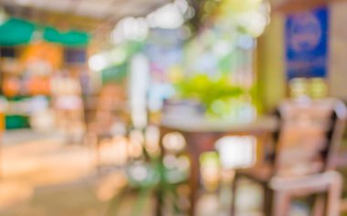 Arka plan kullanımı için yeşil ağaç bokeh ile gündüz vakti bulanık bir restoran görüntüsü .