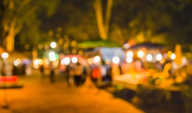 Şenlik ışıklarıyla dekore edilmiş arka plandaki bulanık gece pazarının görüntüsü. (Klasik ton))