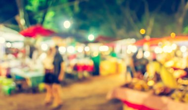 Şenlik ışıklarıyla dekore edilmiş arka plandaki bulanık gece pazarının görüntüsü. (Klasik ton))