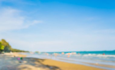 Arka plan kullanımı için sahilde yürüyen bulanık insanların soyut görüntüsü .