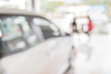 Erkek eli modern bir dokunmatik ekranlı telefon tutuyor ve ticari arabaların görüntüsü araba dükkanının vitrininde duruyor..