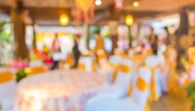 Düğün, akşam yemeği ya da festival etkinliği için hazırlanmış arka plan kullanımı için büyük salonun içindeki güzel ışıklandırma dekorasyonlu büyük yemek masasının soyut bulanık görüntüsü .