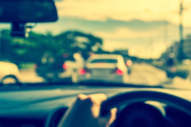 Arka plan kullanımı için gündüz vakti araba kullanan insanların klasik ton bulanık görüntüsü. (içeriden fotoğraf çek)