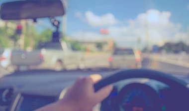 Arka plan kullanımı için gündüz vakti araba kullanan insanların klasik ton bulanık görüntüsü. (içeriden fotoğraf çek)