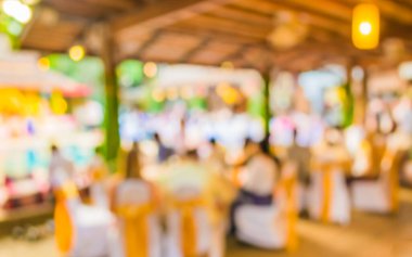 Düğün, akşam yemeği ya da festival etkinliği için hazırlanmış arka plan kullanımı için büyük salonun içindeki güzel ışıklandırma dekorasyonlu büyük yemek masasının soyut bulanık görüntüsü .