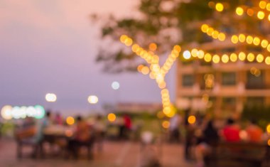Arka plan kullanımı için akşam vakti açık hava restoranında bulanık insanların görüntüsü.