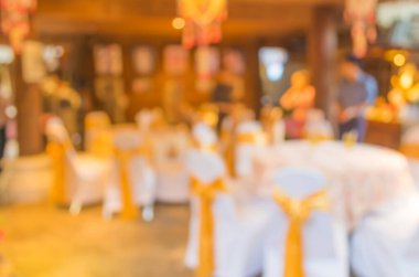 Düğün, akşam yemeği ya da festival etkinliği için hazırlanmış arka plan kullanımı için büyük salonun içindeki güzel ışıklandırma dekorasyonlu büyük yemek masasının soyut bulanık görüntüsü .