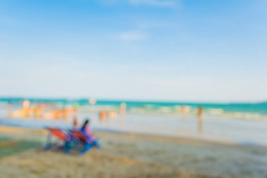 Arka plan kullanımı için sahilde yürüyen bulanık insanların soyut görüntüsü .