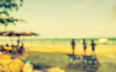 Bulanık insanların görüntüsü ve arka plan kullanımı için Bokeh ile plajda güneşlenmek. (Klasik ton))