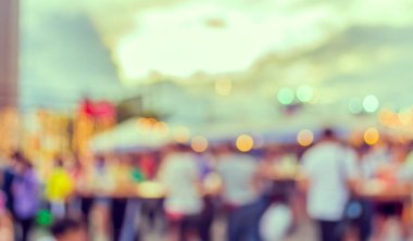 Eskitilmiş ton bulanıklığı, arka plan kullanımı için Bokeh ile gece festivalindeki yemek tezgahının görüntüsü .