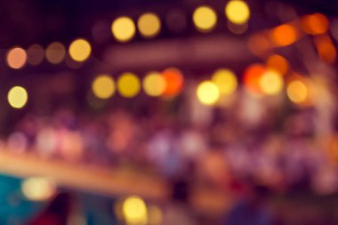 Düğün, akşam yemeği ya da festival etkinliği için hazırlanmış arka plan kullanımı için büyük salonun içindeki güzel ışıklandırma dekorasyonlu büyük yemek masasının soyut bulanık görüntüsü. (Klasik ton))