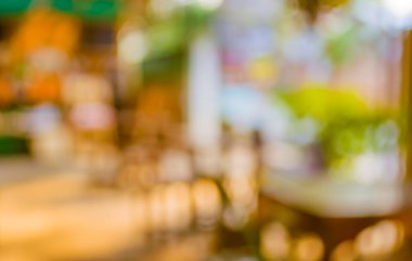 Arka plan kullanımı için yeşil ağaç bokeh ile gündüz vakti bulanık bir restoran görüntüsü .