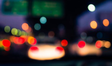 Arka plan için gece vakti trafik sıkışıklığından gelen bokeh ışıkları olan içerideki arabaların klasik ton bulanık görüntüsü.