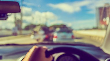 Arka plan kullanımı için gündüz vakti araba kullanan insanların klasik ton bulanık görüntüsü. (içeriden fotoğraf çek)