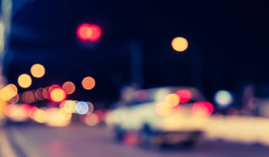 Arka plan kullanımı için gece vakti renkli ışıkları olan bulanık sokak Bokeh 'inin klasik ton görüntüsü .