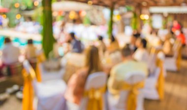 Düğün, akşam yemeği ya da festival etkinliği için hazırlanmış arka plan kullanımı için büyük salonun içindeki güzel ışıklandırma dekorasyonlu büyük yemek masasının soyut bulanık görüntüsü .