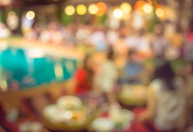 Düğün, akşam yemeği ya da festival etkinliği için hazırlanmış arka plan kullanımı için büyük salonun içindeki güzel ışıklandırma dekorasyonlu büyük yemek masasının soyut bulanık görüntüsü .