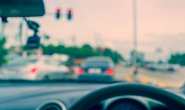 Arka plan kullanımı için gündüz vakti araba kullanan insanların klasik ton bulanık görüntüsü. (içeriden fotoğraf çek)