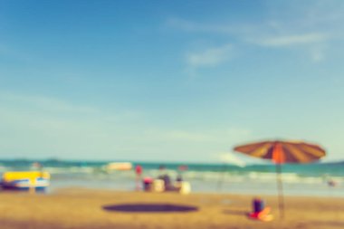 Arka plan kullanımı için sahilde yürüyen bulanık insanların soyut görüntüsü. (Klasik ton))