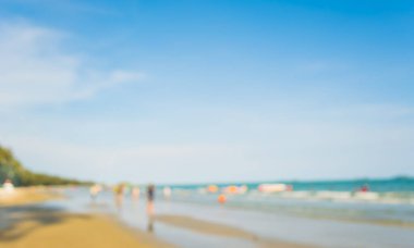 Arka plan kullanımı için sahilde yürüyen bulanık insanların soyut görüntüsü .