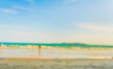 Arka plan kullanımı için sahilde yürüyen bulanık insanların soyut görüntüsü .