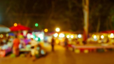 Şenlik ışıklarıyla dekore edilmiş arka plandaki bulanık gece pazarının görüntüsü. (Klasik ton))
