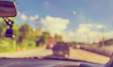 Arka plan kullanımı için gündüz vakti araba kullanan insanların klasik ton bulanık görüntüsü. (içeriden fotoğraf çek)