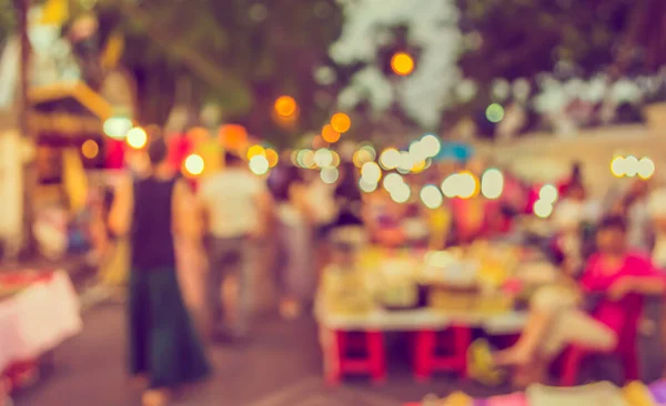 vintage tone blur image of night market on street blurred background with bokeh .