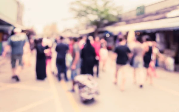 Blurred image of people walking at day market , blur background with bokeh . (vintage tone)