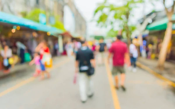Blurred image of people walking at day market , blur background with bokeh .