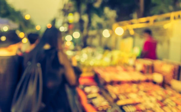 vintage tone blur image of night market on street blurred background with bokeh .