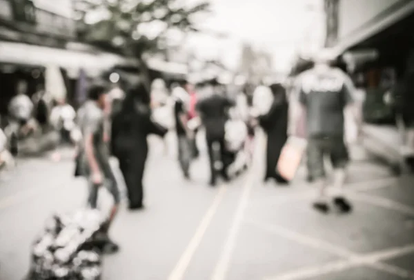 Blurred image of people walking at day market , blur background with bokeh . (vintage tone)