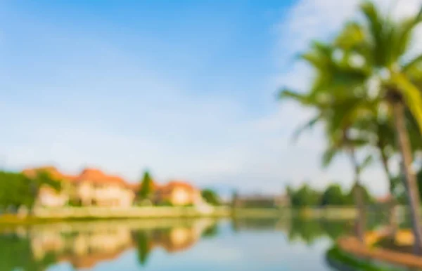 Abstract blur image of property on lake side and blue sky in background .