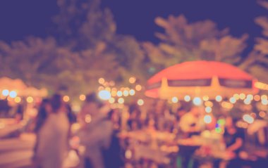 Eskitilmiş ton bulanıklığı, arka plan kullanımı için Bokeh ile gece festivalindeki yemek tezgahının görüntüsü .
