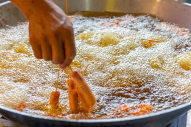 Kızartma için büyük bir tavada büyük miktarda kızgın yağ..