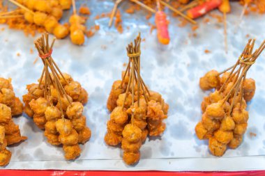 Kızarmış köfte ve yengeç çubuğu. Marketteki masanın üzerindeki yağ lekeleme kağıdıyla kaplı..