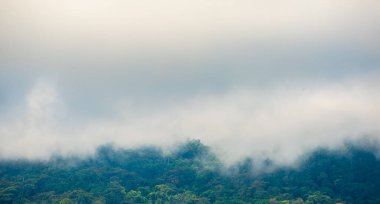 Gün içinde arkaplanda dağ ve bulutlu gökyüzü görüntüsü.