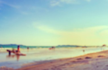 Arka plan kullanımı için sahilde yürüyen bulanık insanların soyut görüntüsü. (Klasik ton))