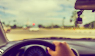 Arka plan kullanımı için gündüz vakti araba kullanan insanların klasik ton bulanık görüntüsü. (içeriden fotoğraf çek)