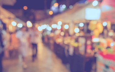 Gece festivalinde arka plan kullanımı için Bokeh ile birlikte sokak pazarının soyut bulanık görüntüsü. (Klasik ton))