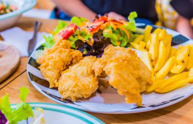 Kızarmış tavuk ve sebze salatasıyla kızartılmış patates. .