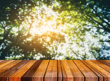 Ahşap tablo ve klasik ton görüntüsü arka plan kullanımı için güneş alan soyut Bokeh yeşil ağaç.