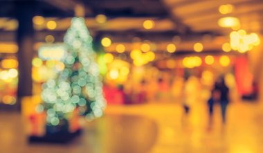 Alışveriş merkezinin soyut bulanık görüntüsü ve arka plan için noel zamanı insanları. (Klasik ton))