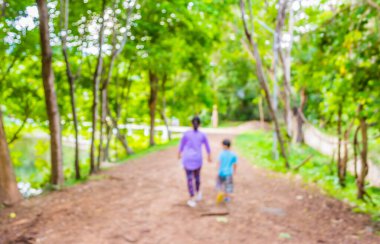 Arka plan kullanımı için Bokeh ile parkta yürüyen insanların bulanık görüntüsü .